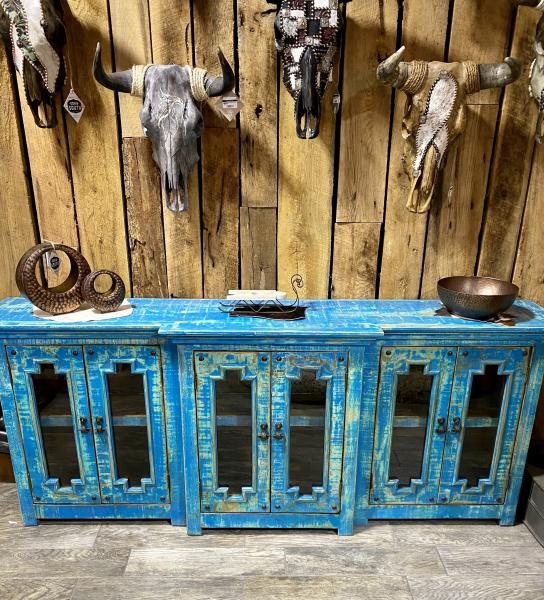 Painted a beautiful blue, this buffet offers lots of space to display your china, silver or prized possessions. Hand Carved out of solid wood. It has six glass paned doors with two shelves.