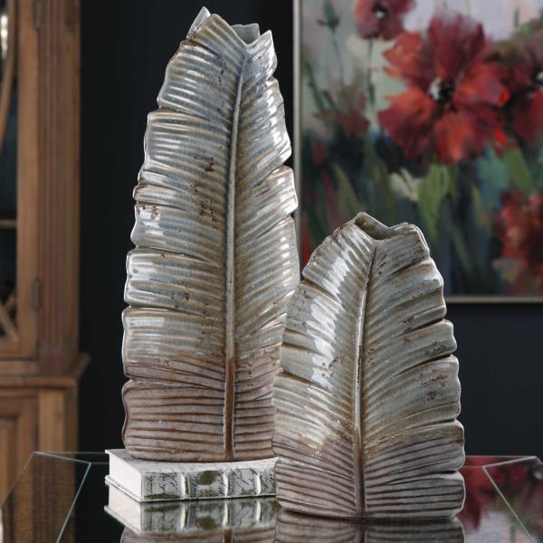 Textured, distressed ceramic leaf vases finished in a pale blue, ivory and bronze glaze. Due to the nature of fired glazes on ceramic