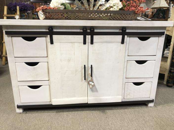Solid wood handmade TV Stand painted a rustic white and adorned with black iron hardware.

Six drawers and two shelves behind a sliding barn-style door offer plenty of space for games, movies, pictures, or anything else you want close at hand.
